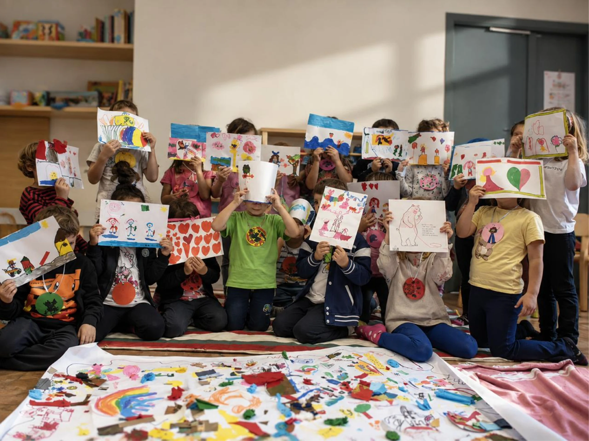 Bambini mostrano i lavori realizzati durante un laboratorio creativo